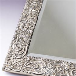 Late Victorian silver mounted dressing table mirror, the frame decorated with scrolls and oval cartouche initialled 'C', bevelled plate on an easel stand 57cm x 38cm London 1899 Maker Charles Henry Dumenil 