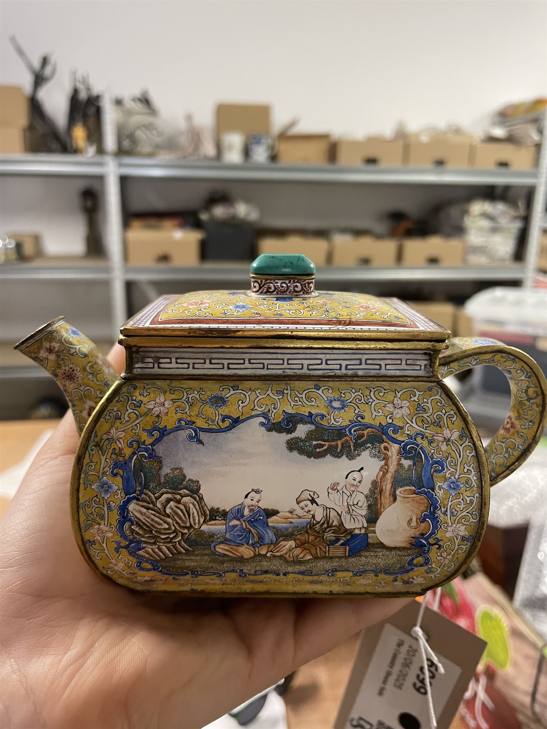 Chinese Qianlong enamel bombé shaped teapot, decorated with scenes of scholars examining a scroll and drinking on a yellow ground with various traditional floral and foliate motifs, the painted scene framed within trailing blue vine border, with Qianlong marks to base L15cm