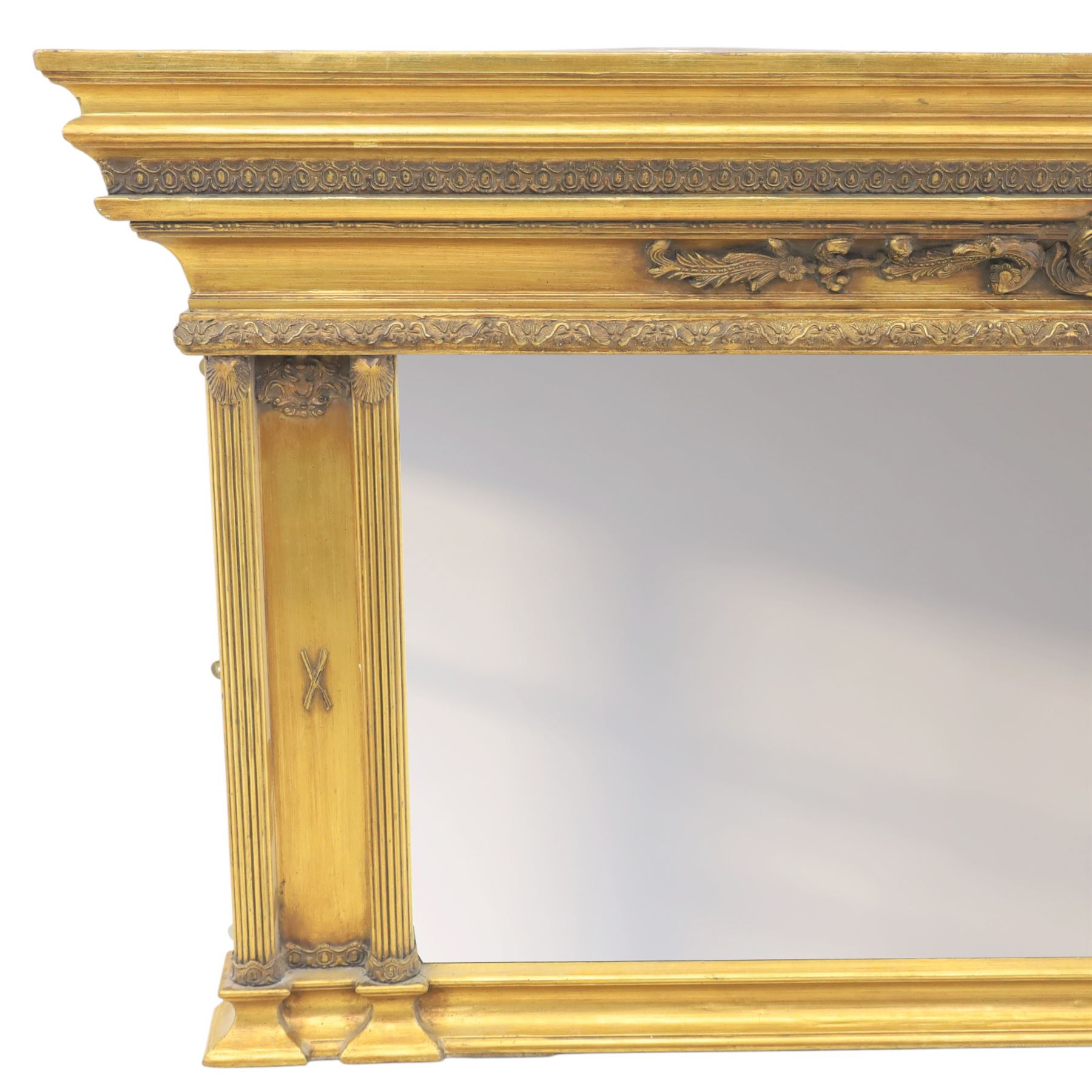 Early 20th century gilt over mantel mirror, the rectangular plate within stepped and moulded frame with central applied foliate ornament and fluted side uprights