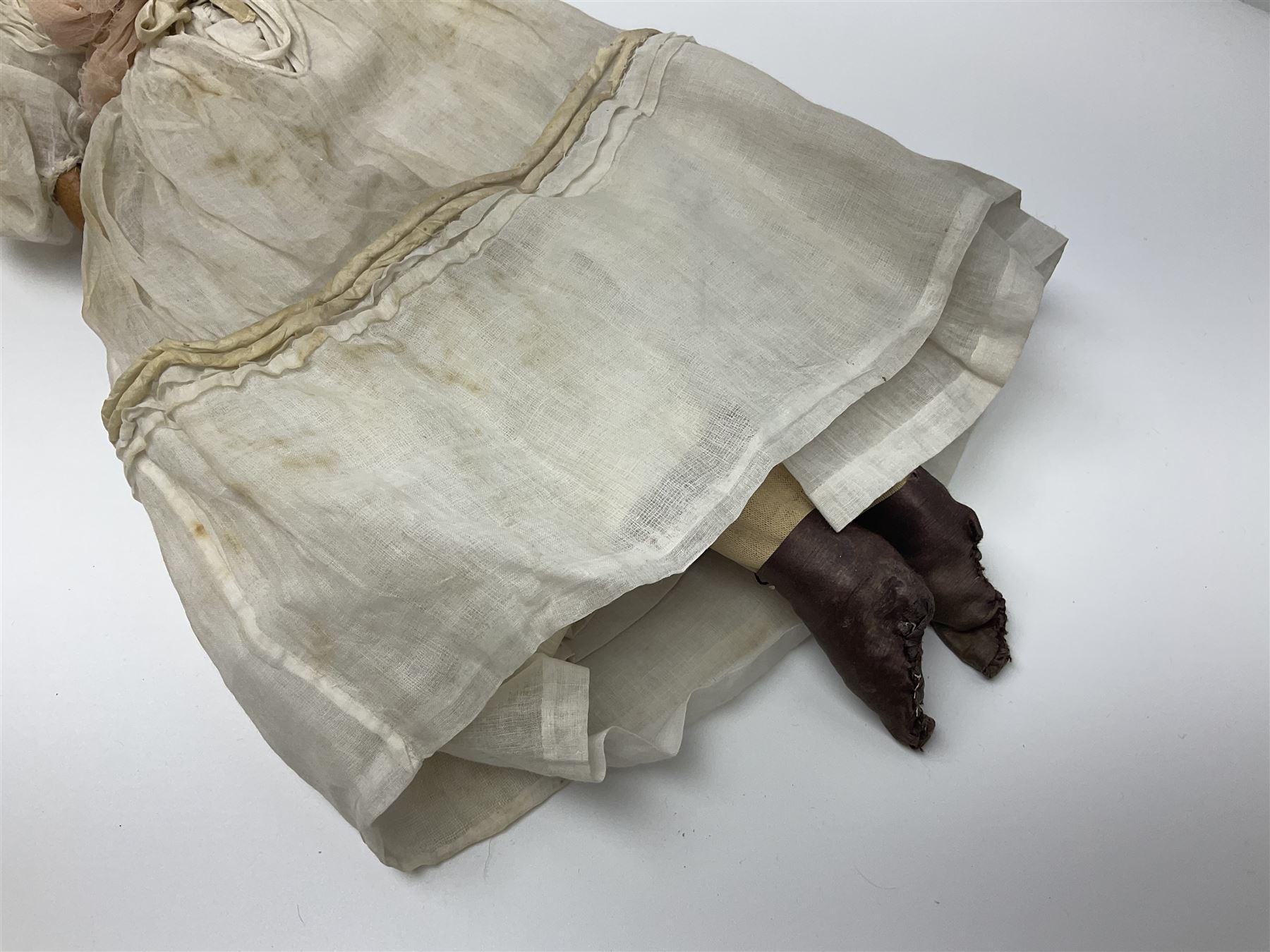 Victorian wax shoulder head doll with pale complexion, applied hair, inset glass eyes and fabric covered jointed body with kid leather lower arms; white linen dress and undergarments H50cm