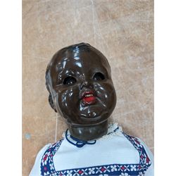 Mid 20th century black baby doll, with moveable head and limbs, sleepy eyes and moulded hair and features, L65cm