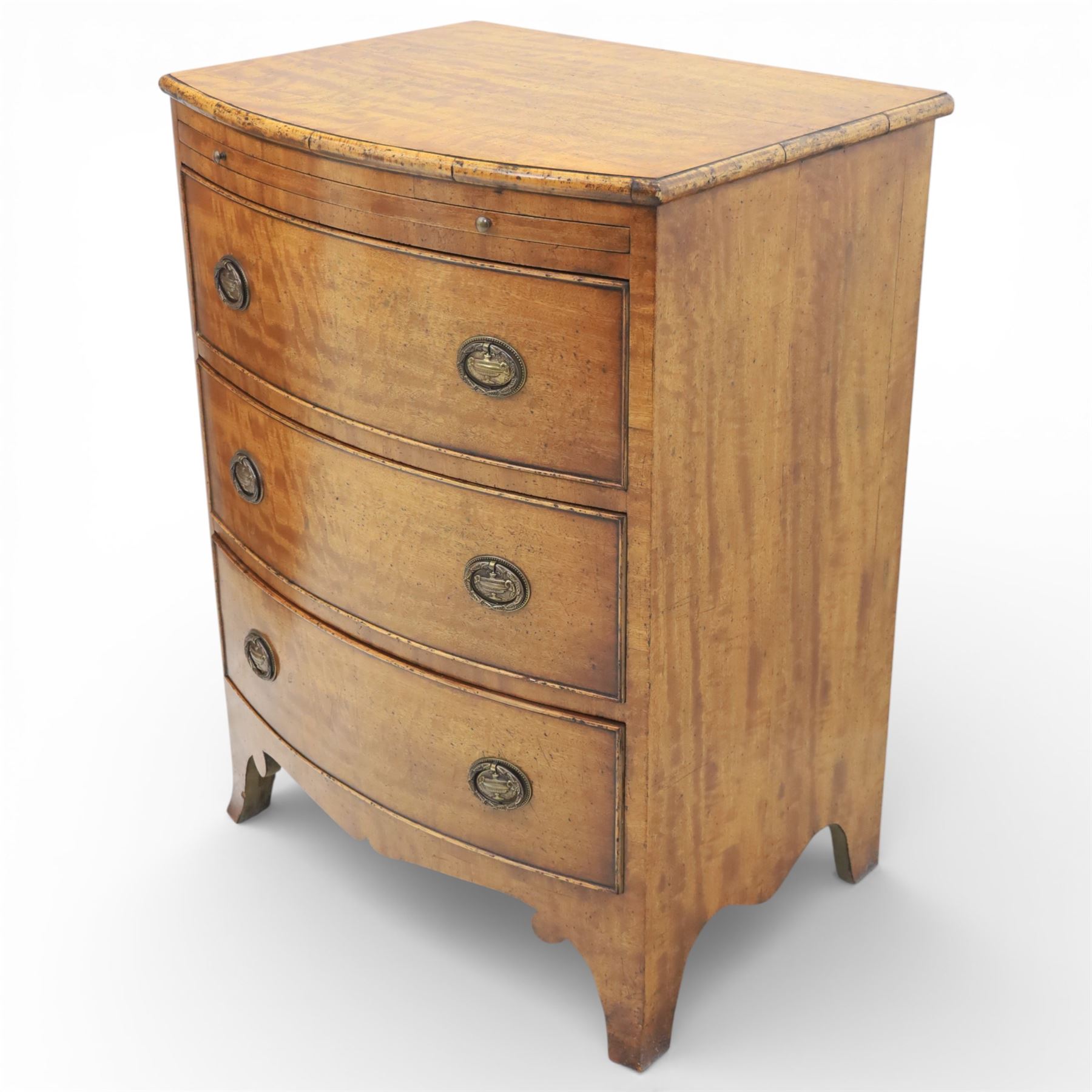 Georgian design bow front chest in figured walnut veneers, with moulded top over a pull-out brushing slide and three long drawers fitted with oval brass drop handles, raised upon swept bracket feet