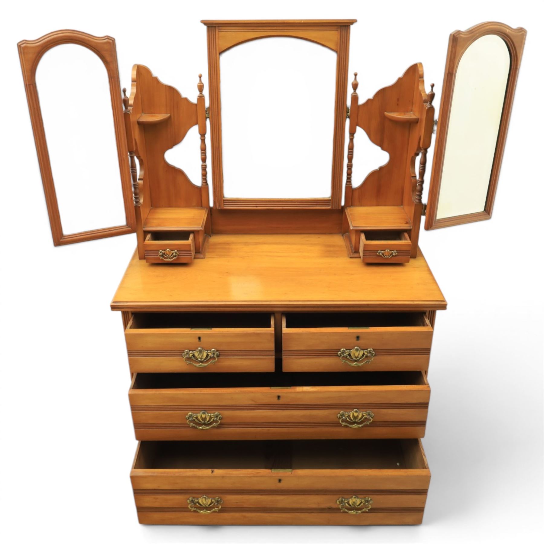 Edwardian satinwood dressing chest, rectangular moulded top over two short and two long drawers with brass drop handles, raised mirror back with arched central plate flanked by hinged side mirrors, small fitted trinket drawers and shaped pierced side supports with turned uprights