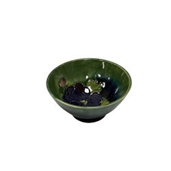 Small Moorcroft bowl decorated with dark blue flowers upon blue green ground, with impressed marks beneath