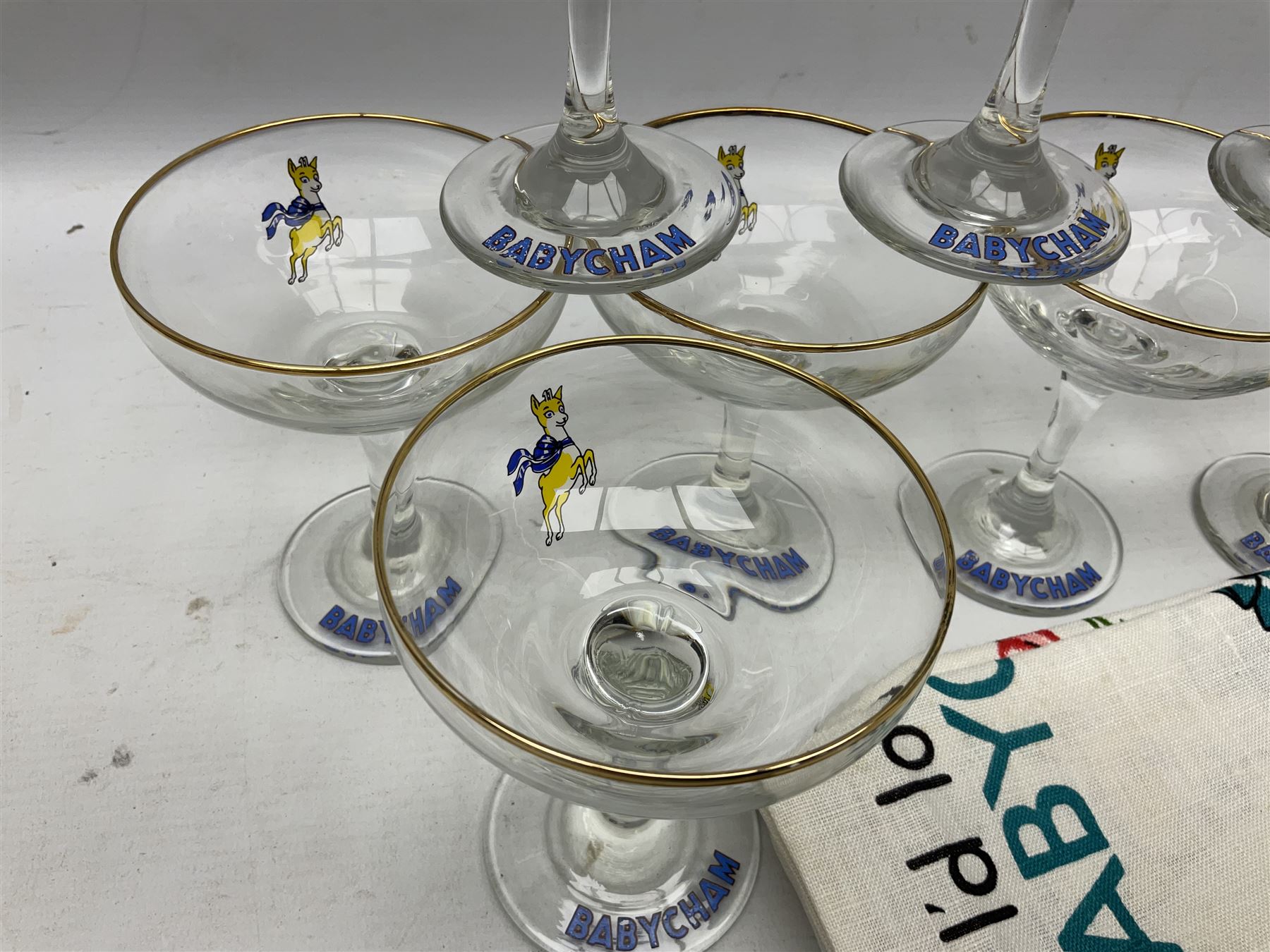 Breweriana; Eight Babycham glasses together with a Babycham plastic fawn mascot and linen I'd Love a Babycham tea towel