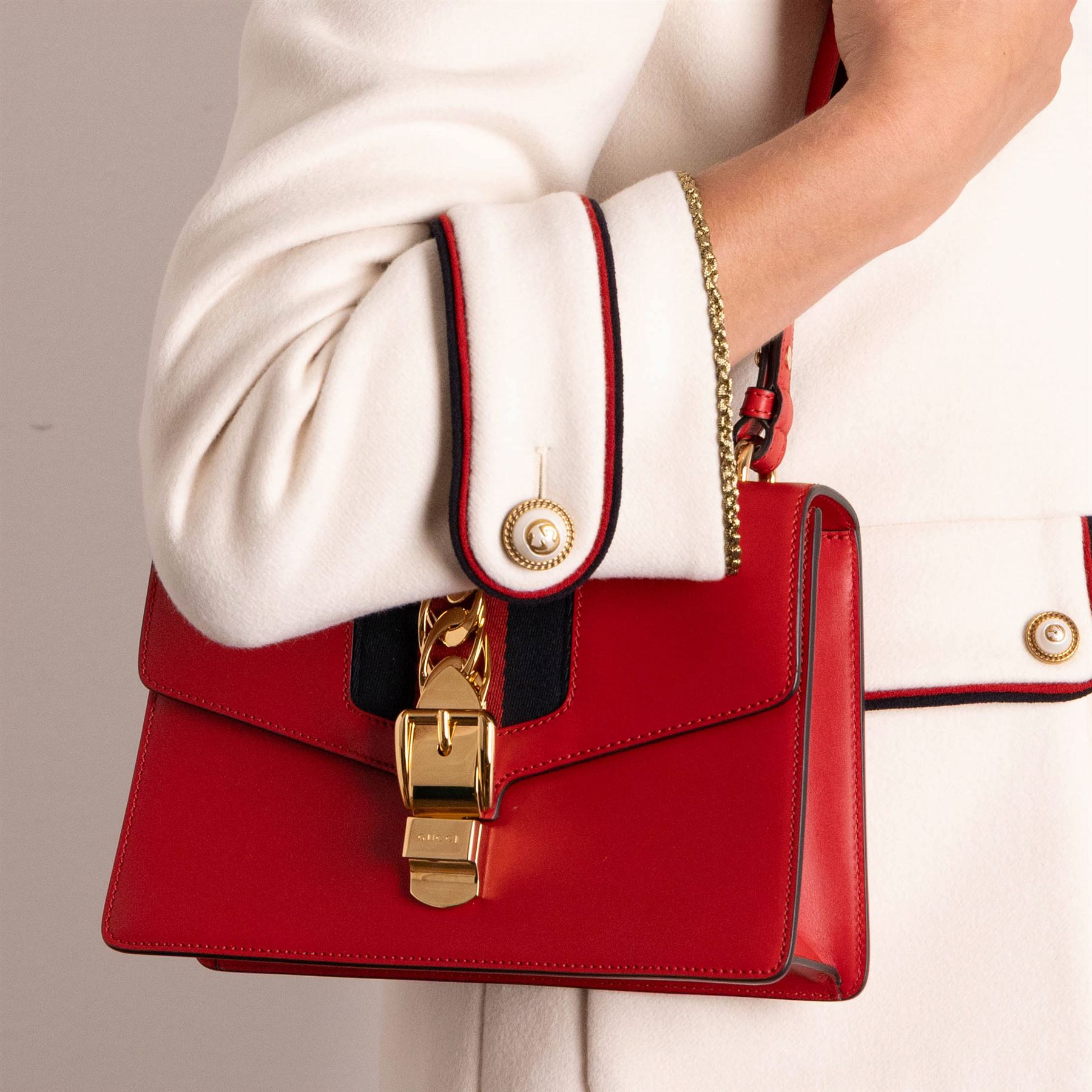 Gucci - ‘Sylvie’ Small Shoulder Bag, introduced circa 2016 under Alessandro Michele, in red calfskin leather with signature web stripe, gold-tone chain and buckle fastening and hardware, flat leather shoulder strap with alternative web-stripe grosgrain strap, unused with original dust bag