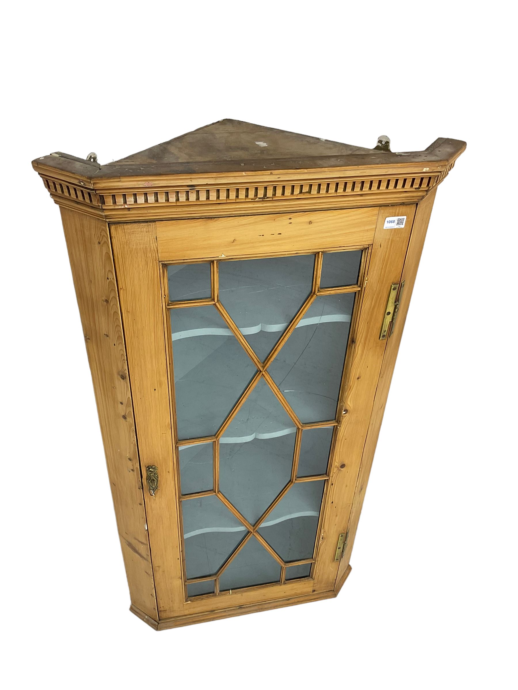 Early 19th century pine corner cabinet, projecting dentil cornice over astragal glazed door