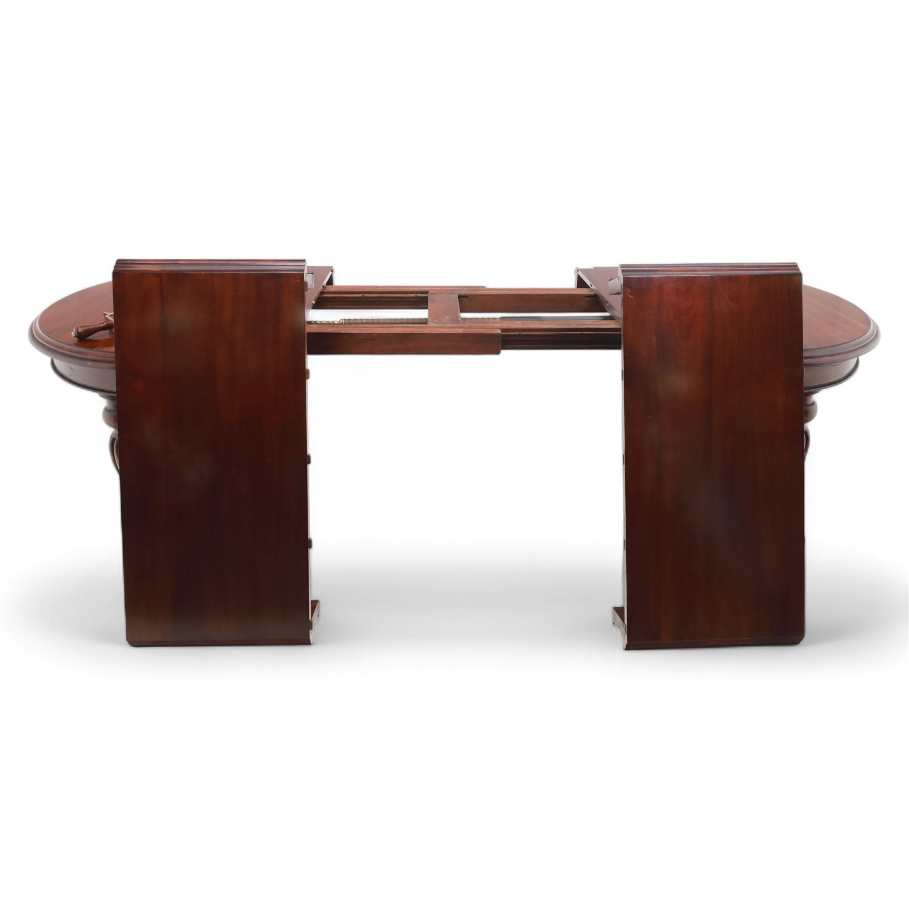 Victorian mahogany extending dining table, rounded rectangular top with moulded edge, pull-out action fitted with two additional leaves, raised on four reeded and fluted baluster legs with brass caps and castors