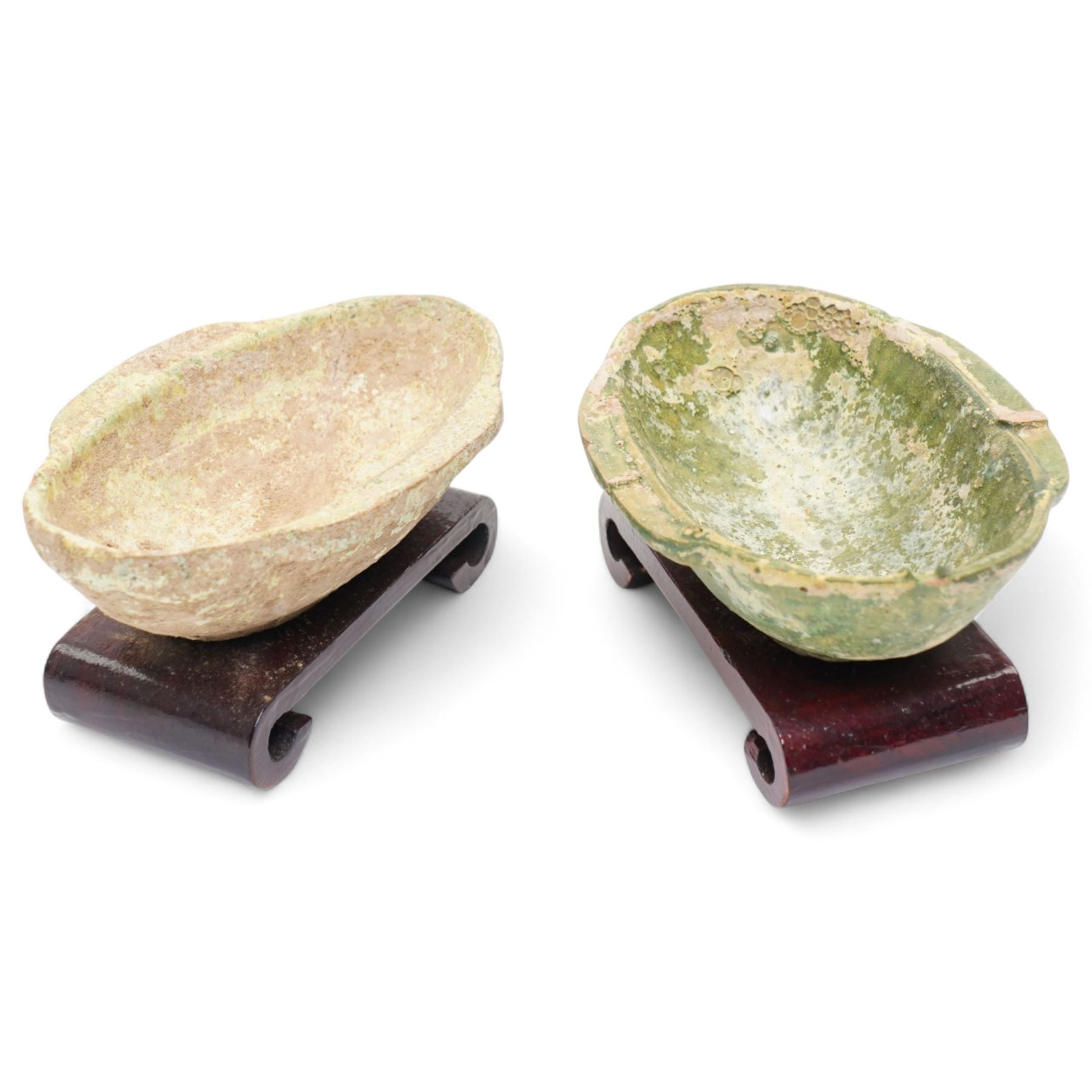 Two small Chinese terracotta 'ear' shaped wine cups, probably Western Han Dynasty c.206BC-24AD, one with green glaze, each on hardwood stand, W12cm (2)