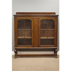  Early 20th century oak bookcase fitted with two glazed doors, W130cm, H135cm, D37cm  