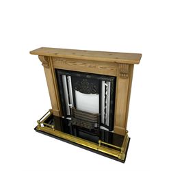 Cast metal fireplace in pine surround, decorated with foliate scrolls and flower heads, black granite hearth and brass fender, together with optional gas fire fitting