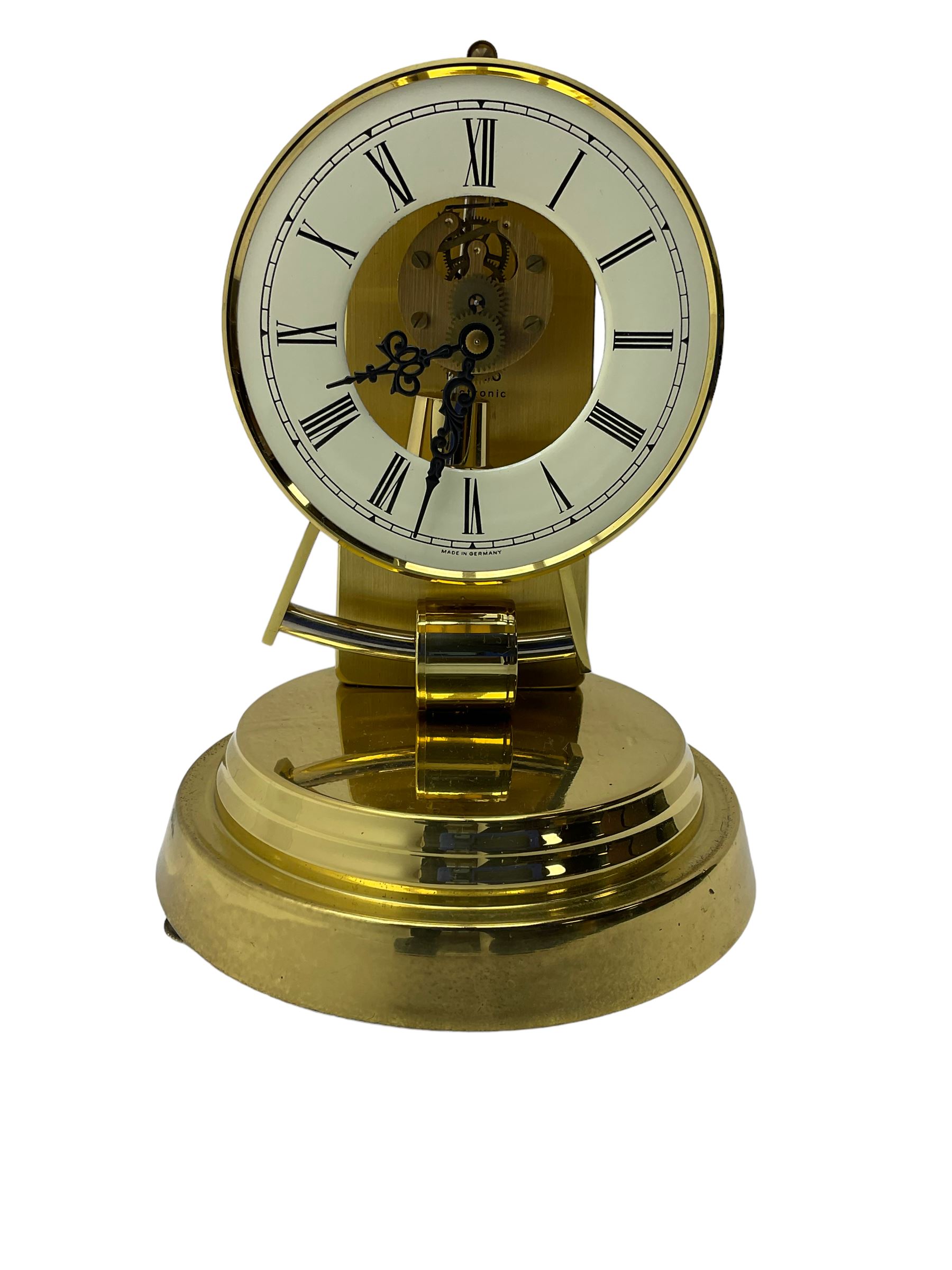  A late 20th century -  German Kieninger & Obergfell, “Kundo” battery operated
mantle clock under an acrylic shade, with an electrically operated solenoid pendulum housed on a circular brass base, skeleton movement with visible motion work through a painted 4-1/2” open chapter ring, with pierced steel hands, Roman numerals and minute track.