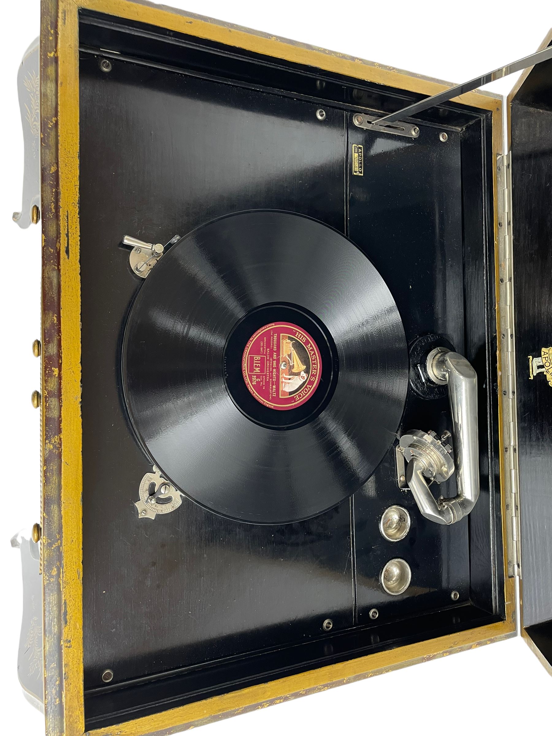 Early 20th century Chinoiserie lacquered gramophone cabinet, the lid decorated with raised gilt work, traditional landscape and figural scenes, fitted with 'Apollo' 'No. 114' gramophone, cupboards below, on cabriole supports