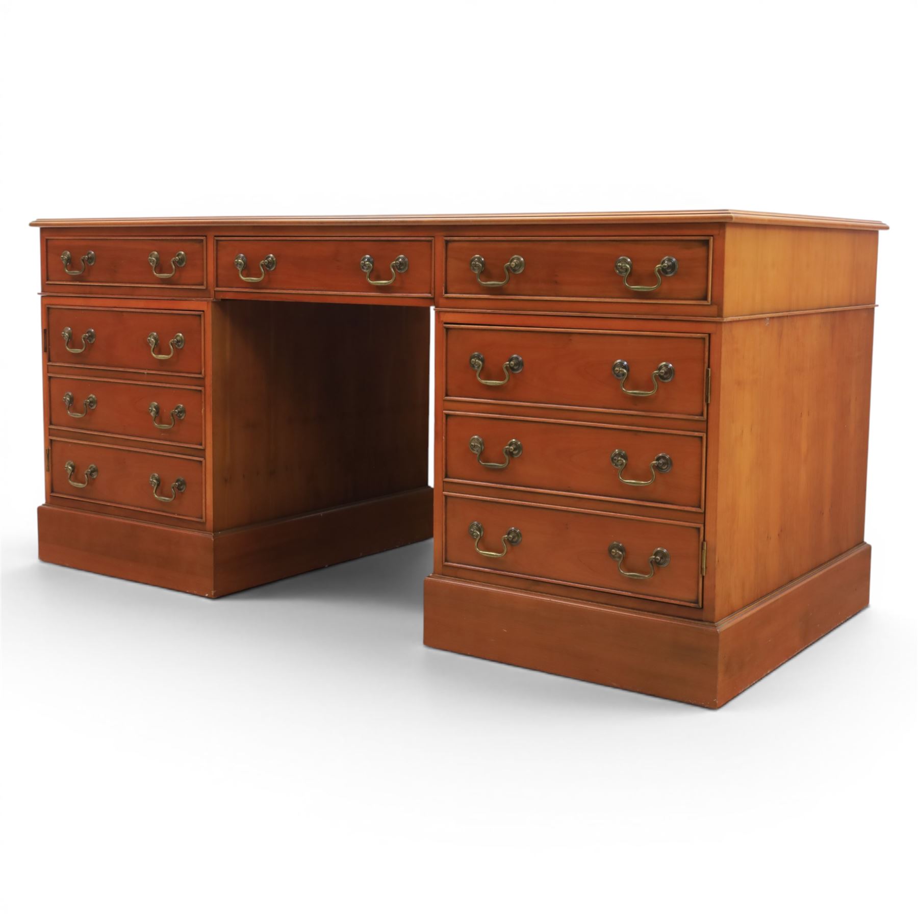 Georgian design yew wood twin pedestal office desk, the top featuring an inset leather writing surface, with drawer drawers and centre keyboard slide, all above two cupboards with slide out shelves
