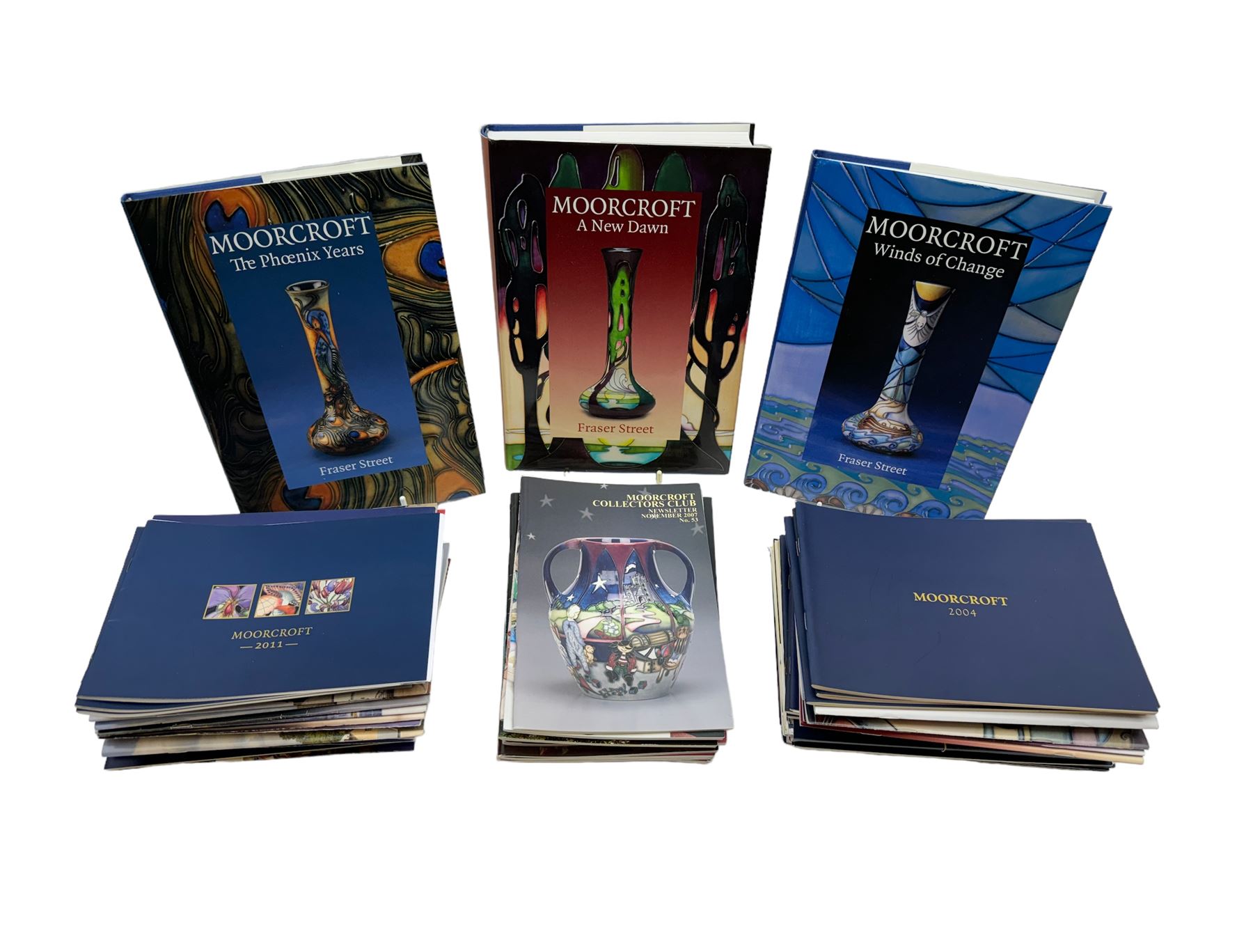 Three Moorcroft reference books, comprising Winds of Change, The Phoenix Years and A New Dawn, together with a collection of Moorcroft magazines 