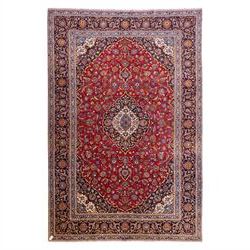 Central Persian Kashan hand-knotted carpet, rich crimson red field with a central cusped m...