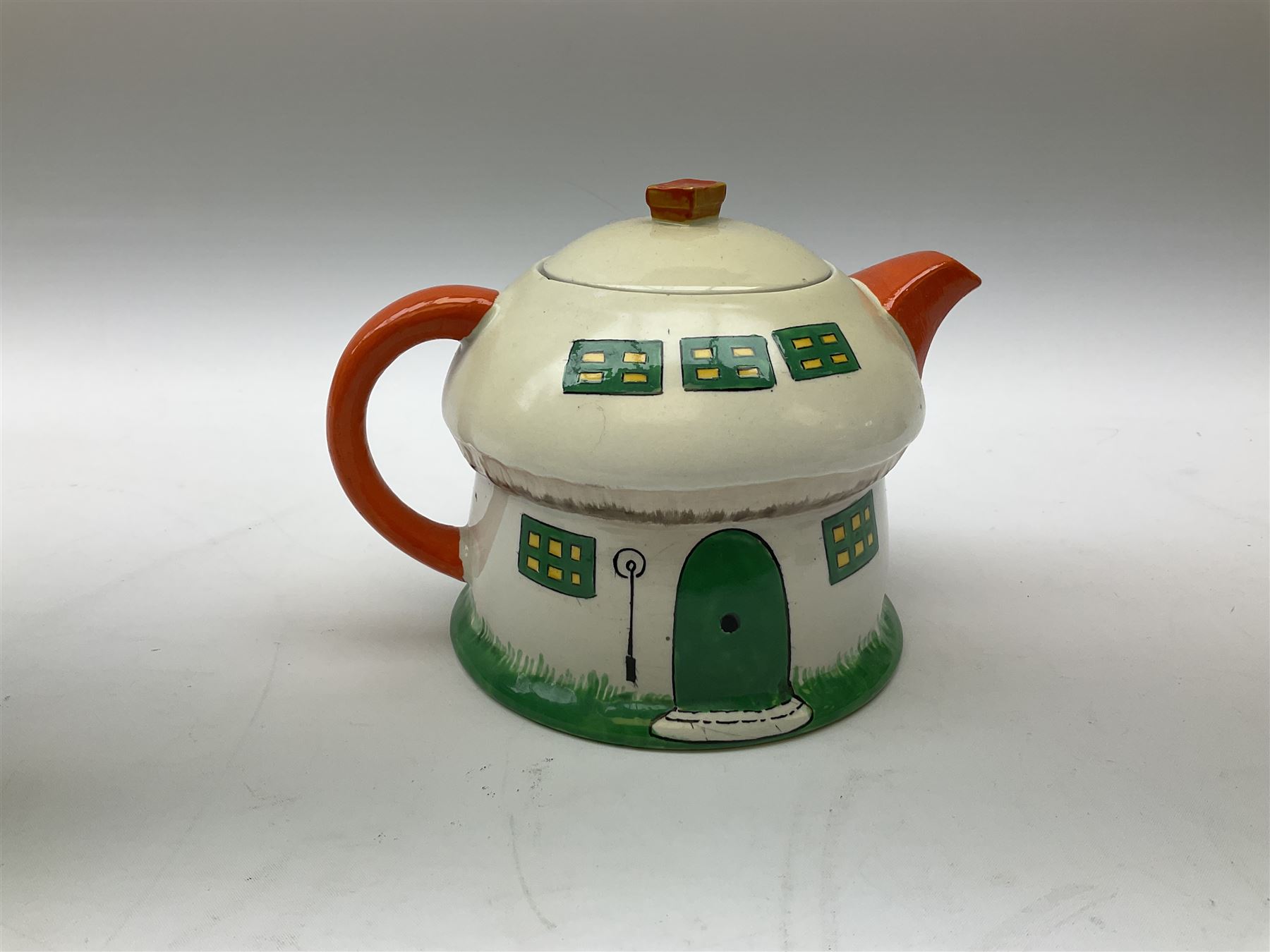 Shelley Boo Boo three piece tea set designed by Mabel Lucie Attwell, comprising teapot modelled as a house, sugar bowl modelled as a toadstool, and creamer modelled as an elf, each with printed marks beneath, together with a Shelley Mabel Lucie Attwell teacup and saucer. 