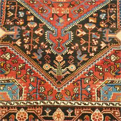 North West Persian Heriz hand-knotted rug, indigo and madder red field with a central angular medallion with stylized floral and geometric motifs within multiple patterned borders with fringe ends 