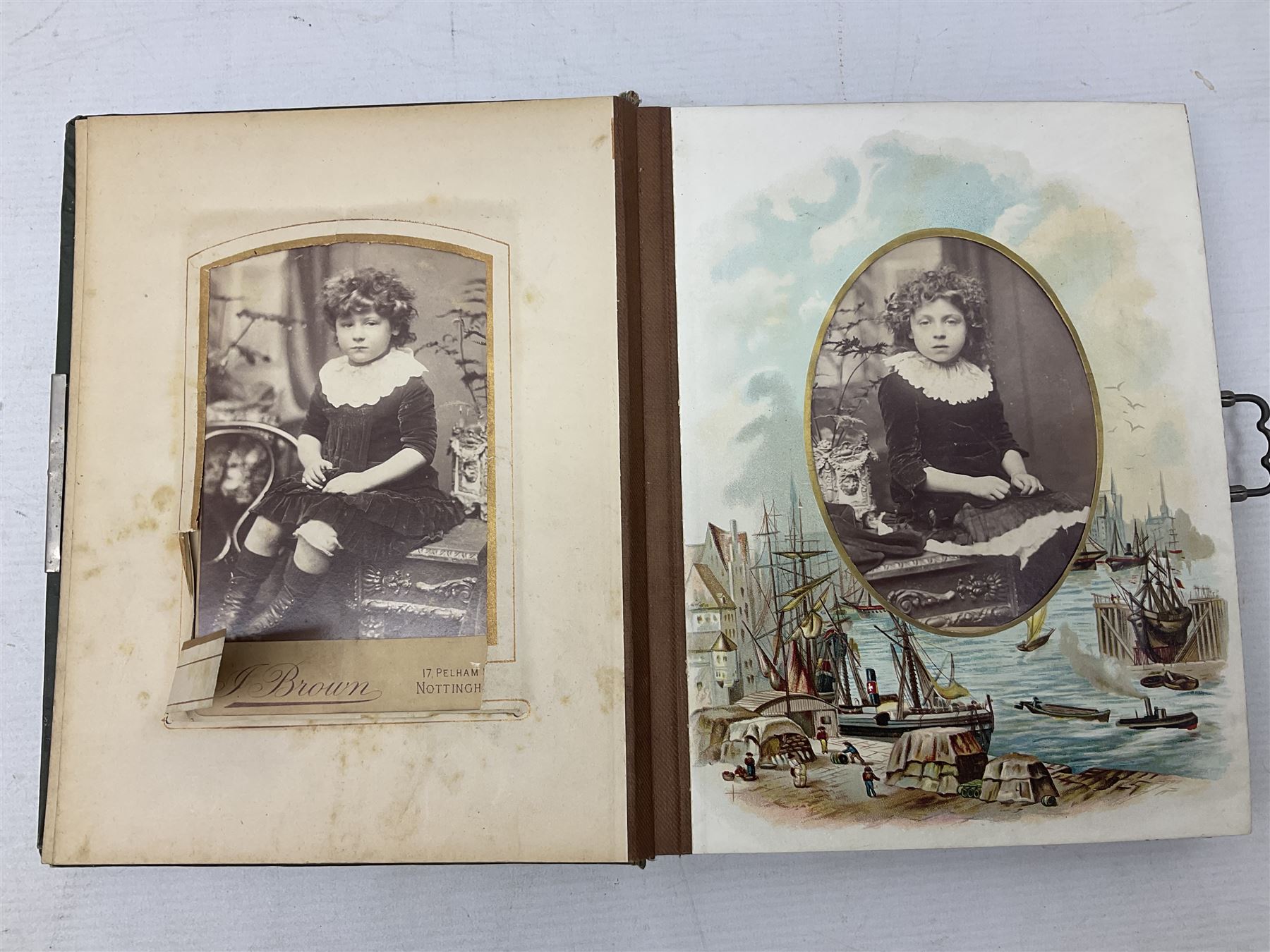Victorian desk ink blotter, decorated with painted spray of flowers within stylised gilt rococo spandrels with mother of pearl fixings, together with a Victorian photo album containing interior leaves with apertures of various sizes and shapes of portraits surrounded by printed sea and dock scenes, blotter L28cm
