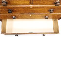 Georgian oak and mahogany housekeepers cupboard, the upper section with projecting cornice, crossbanded and inlaid frieze, above panelled doors with bone escutcheons, enclosing three fixed shelves, flanked by barley twist quarter pilasters, the lower section with further crossbanded and inlaid frieze, two short over two long graduating drawers with ebonised handles, raised on turned supports 