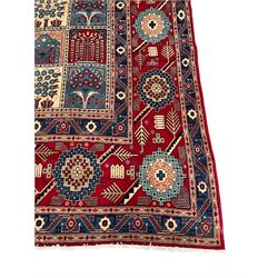 Persian Bakhtiari crimson ground carpet, the field divided into seventy panels decorated tree of life motifs, mihrabs and stylised plants, the border decorated with repeating circular medallions formed of Hac motifs, floral pattern guard stripes 