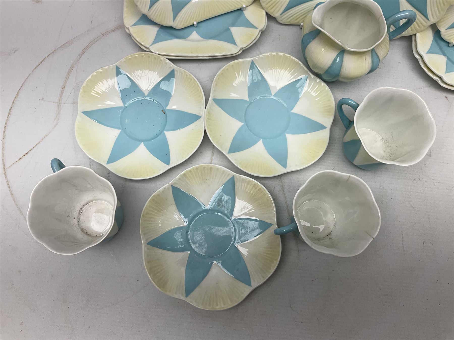 Shelley Dainty pattern tea wares, of lobed form with blue star decoration on merging white and yellow ground, comprising five teacups, five saucers, six tea plates, milk jug and cake plate, all with printed green mark beneath, some with painted pattern no 11770