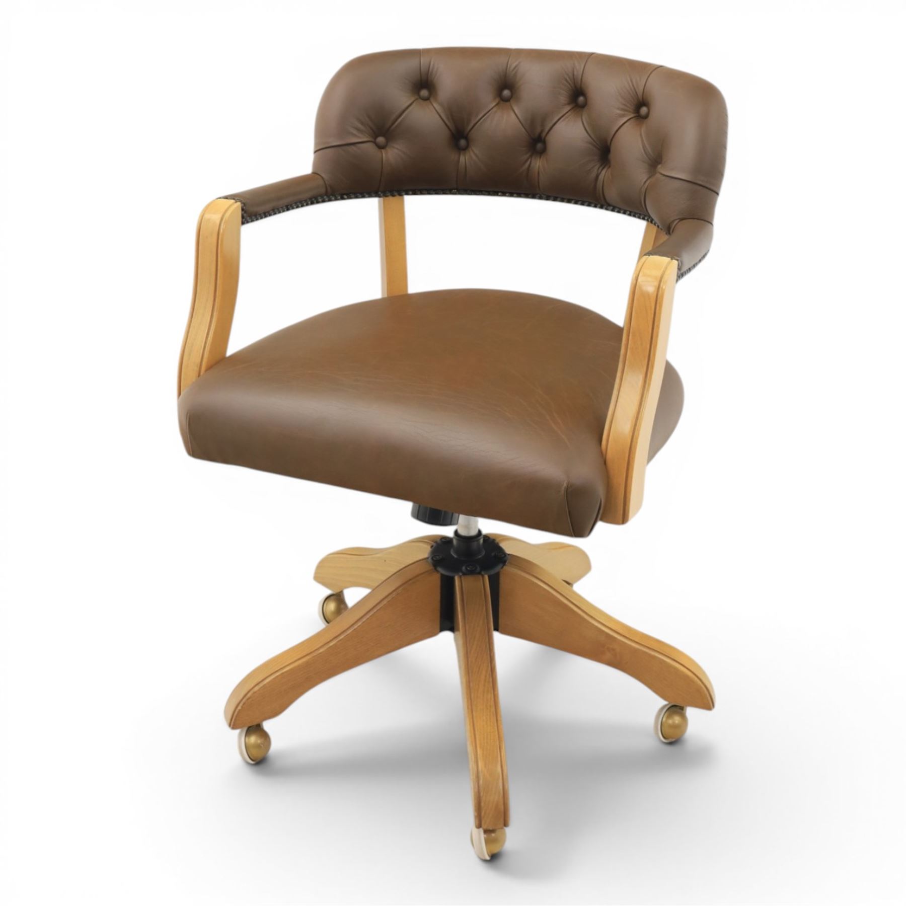 Captain's swivel desk chair upholstered in buttoned tan leather, button backed chair rail, padded and downswept arms, raised on a six point base with castors