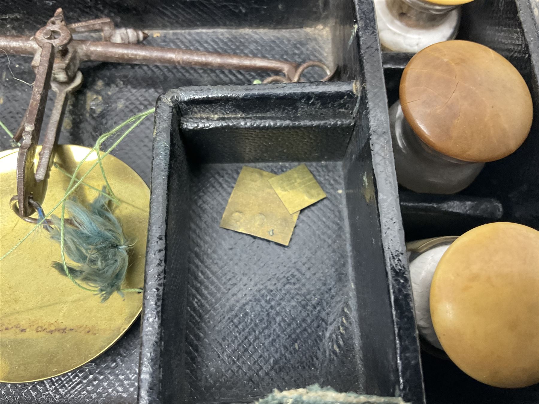 19th century apothecary leather carrying case, with key, the hinged lid opening to reveal seventeen glass medicine bottles with stoppers, most with chemist labels, gram scales, and domestic medicines booklet, H9cm, L27cm