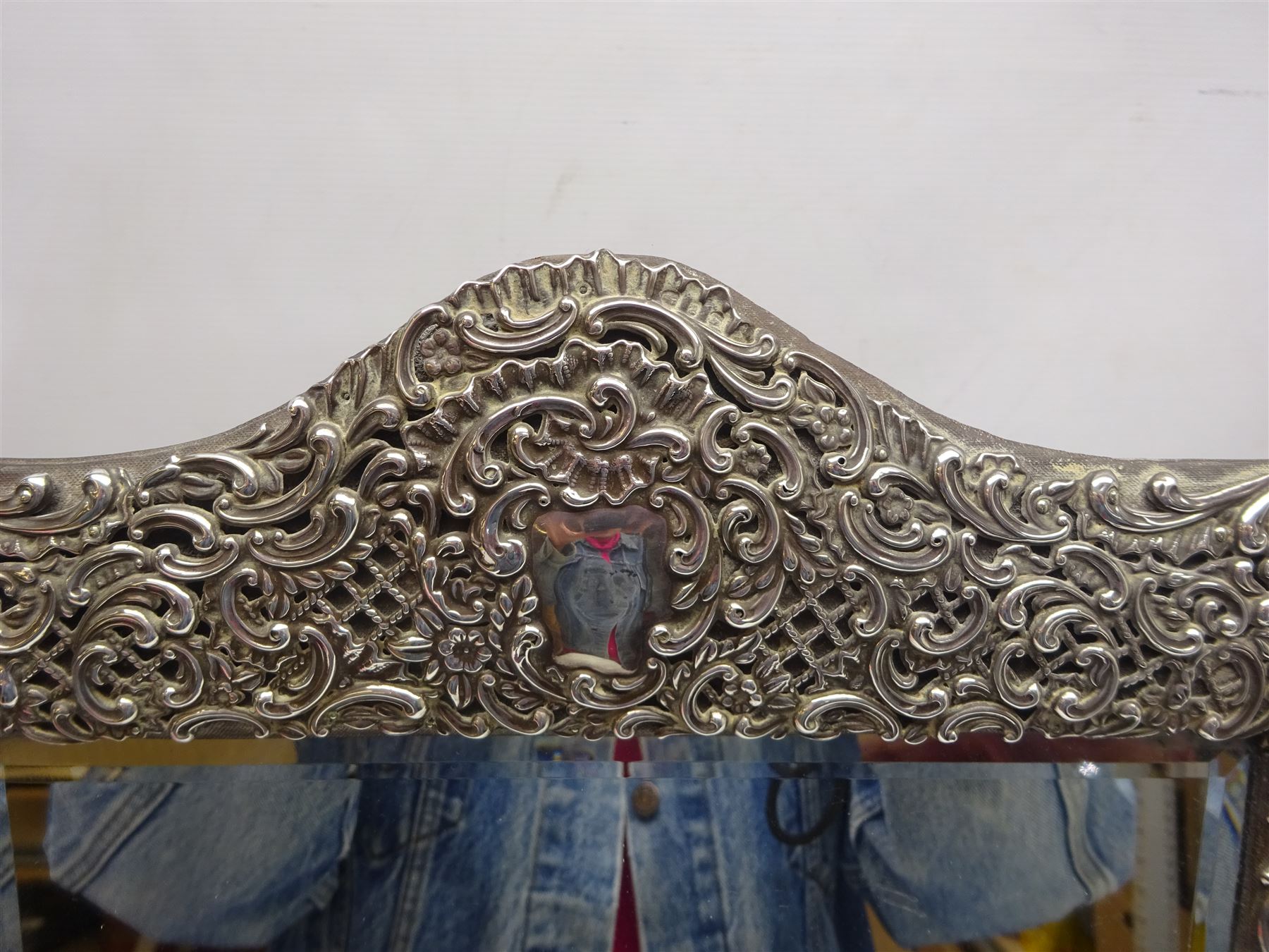 Early 20th century continental silver mounted dressing table top mirror, of rectangular form, the frame embossed with vacant reserve, lattice work, flower heads and C scrolls, with easel style support verso, unmarked but tests as silver, overall H49.5cm W31.5cm