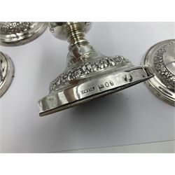 Four George III silver candlesticks, each upon knopped stem and weighted circular stepped foot, the foot and removable sconce repousse decorated with a band of flower heads, hallmarked to sconce and foot Thomas & John Settle, Sheffield 1820, H17.5cm