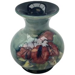 Moorcroft vase, decorated in the Leaf and Berries pattern upon a tonal green ground, together with a further Moorcroft vase, of squat baluster form, decorated in the Iris pattern upon a tonal green ground, each with impressed marks beneath, each H9cm. 