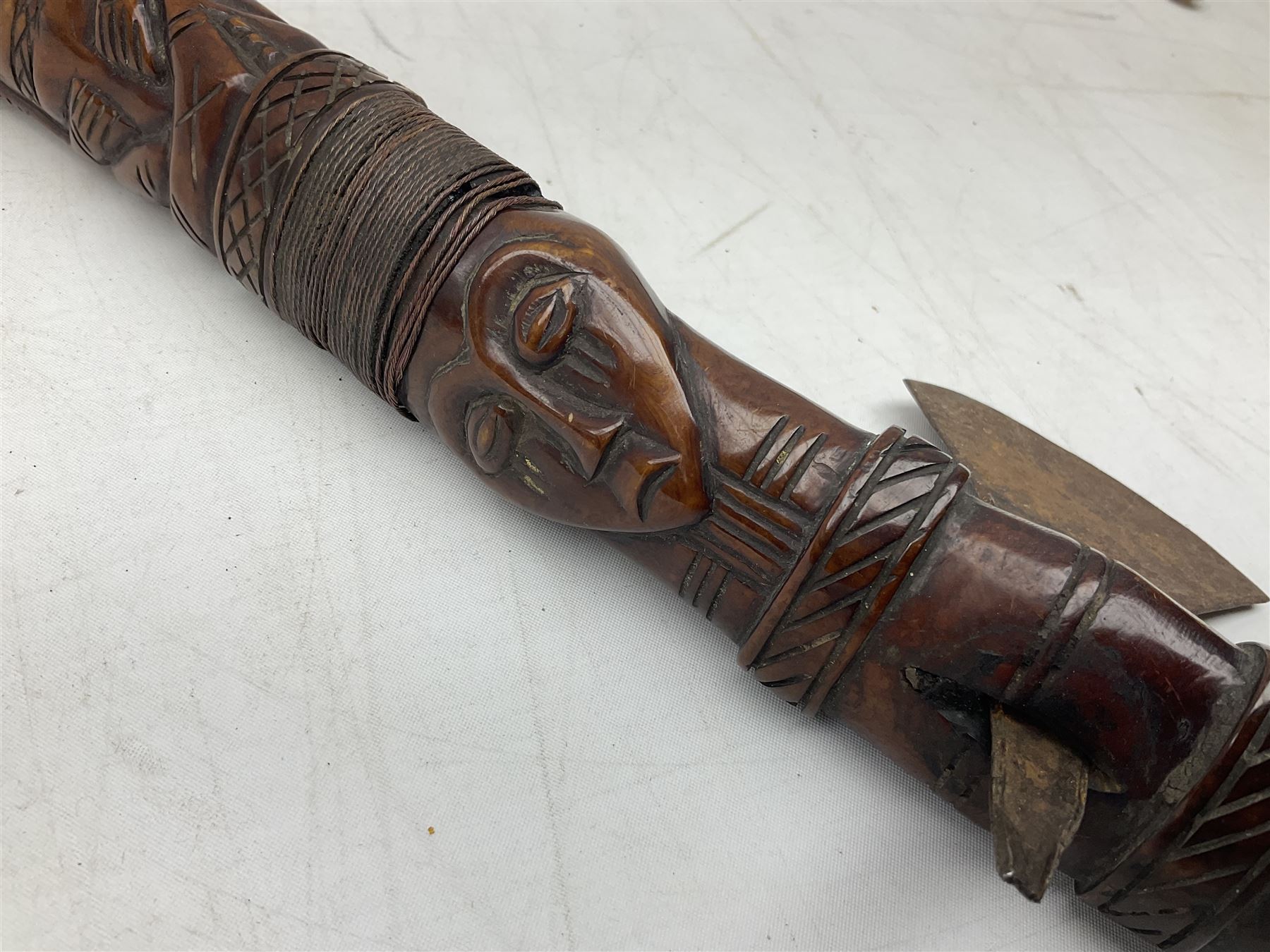 Tribal Art - an African axe, possibly Yoruba, the bone shaft carved as two cord bound stylised figures with iron fan-shaped blade, L35cm overall; and 19th century harpoon or spear head of square section with two long fixing arms on cut-down ash shaft L57cm (2)
