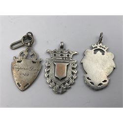 Seven early 20th century silver gold faced cartouche fobs, to include a double sided example, bordered by laurel leaves and six others, all hallmarked with various dates and makers
