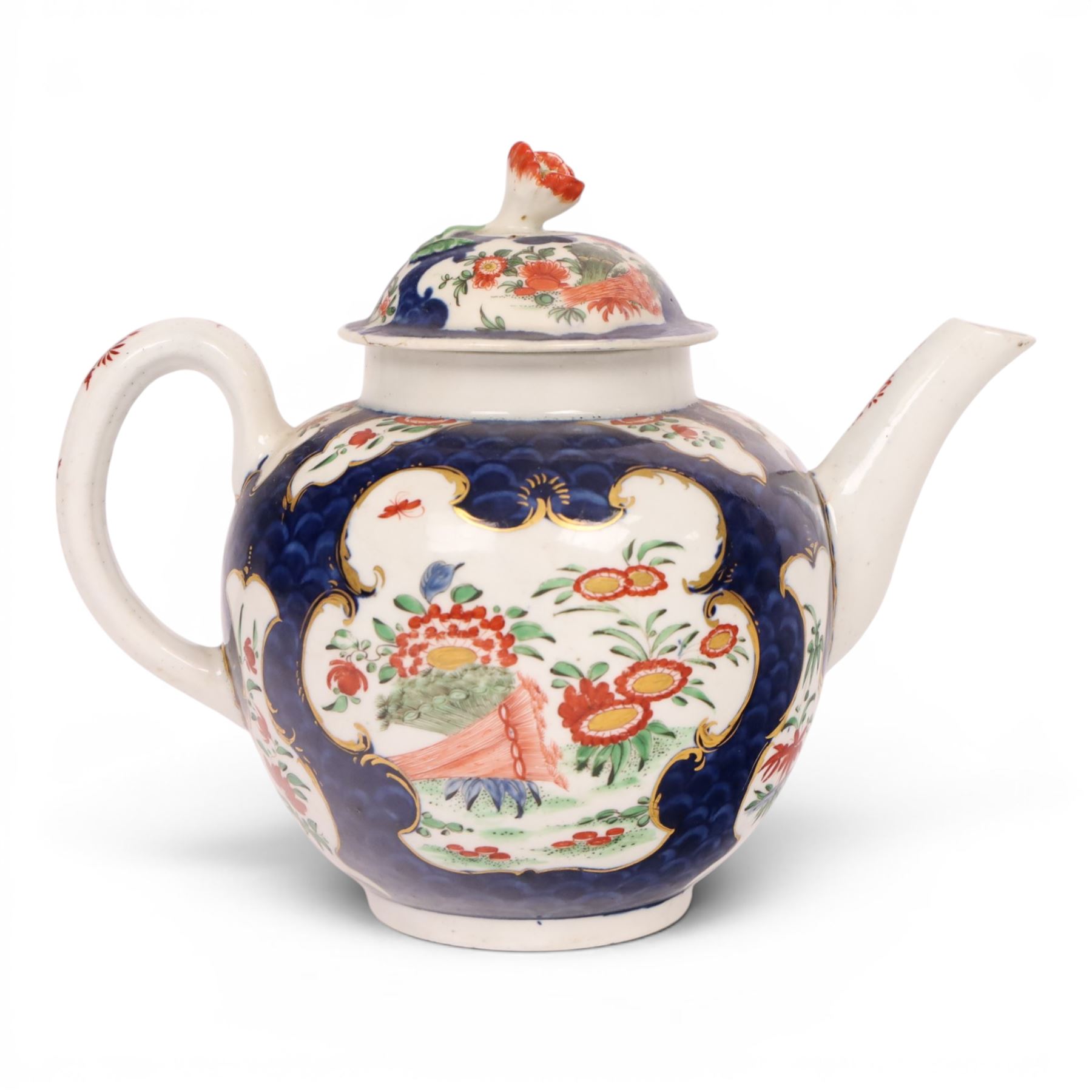 18th century Worcester teapot, circa 1763-70, of globular form, painted with shaped panels of chrysanthemums and banded hedges on a blue scale ground, cover with flower finial, mark beneath, H15cm