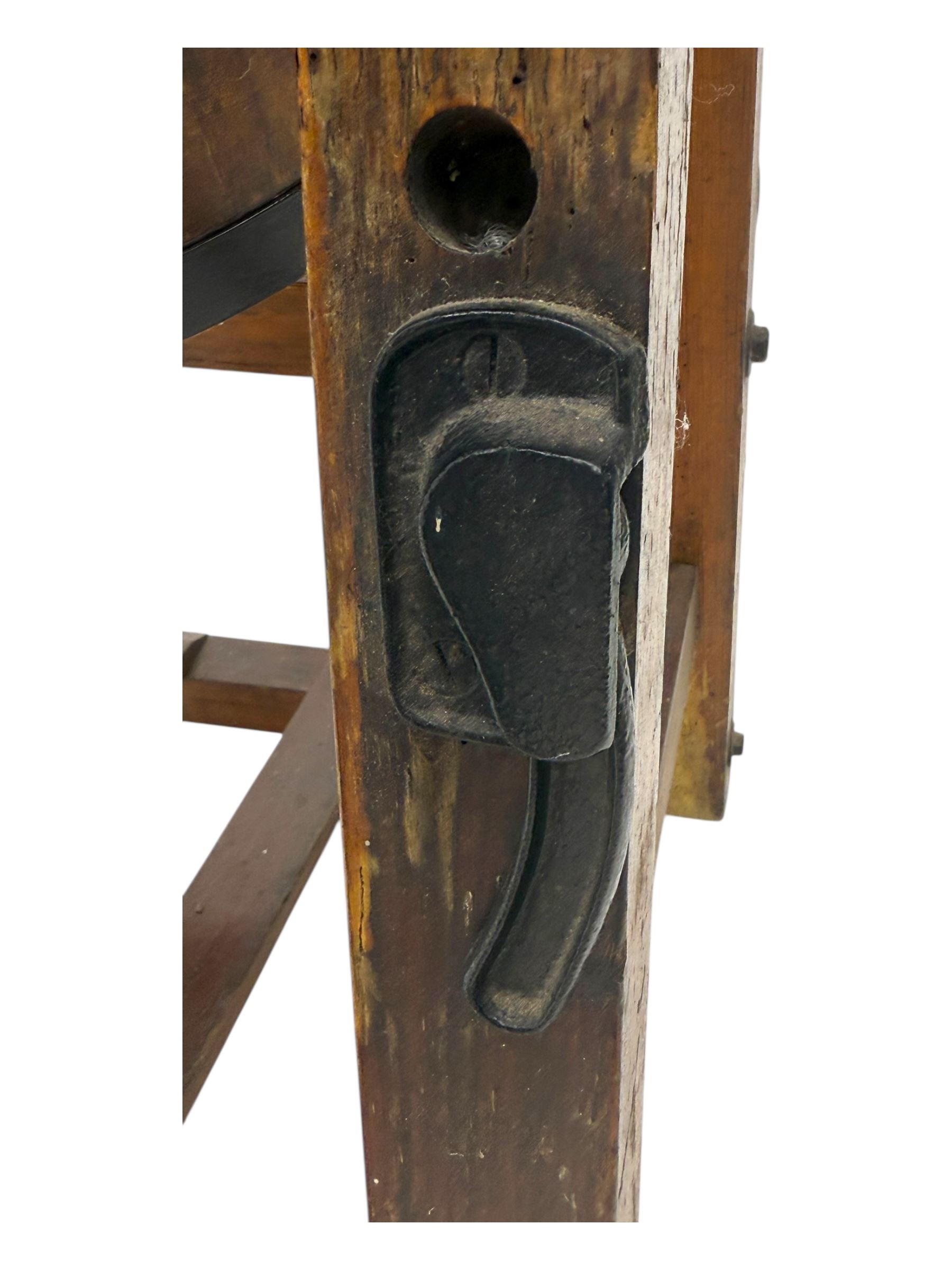 19th century oak and cast iron rotary butter churn, with coopered barrel body, domed lid with filler opening and cast iron securing arms, on tilting iron-mounted frame with crank handle and support rails