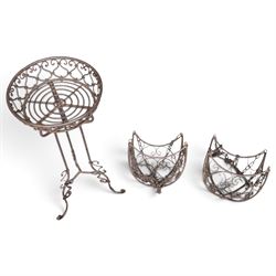Three wrought iron garden basket planters, comprising a circular pierced and scrolling basket on tall tripod stand with scrolling supports (W31cm H76cm), and a pair of matching hanging baskets (W37cm H30cm)