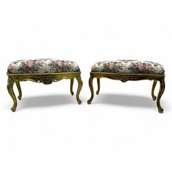 Pair of Louis XV-design giltwood stools, each upholstered in floral tapestry fabric, the carved frame adorned with scrolling foliage and shell motifs, raised on cabriole supports
