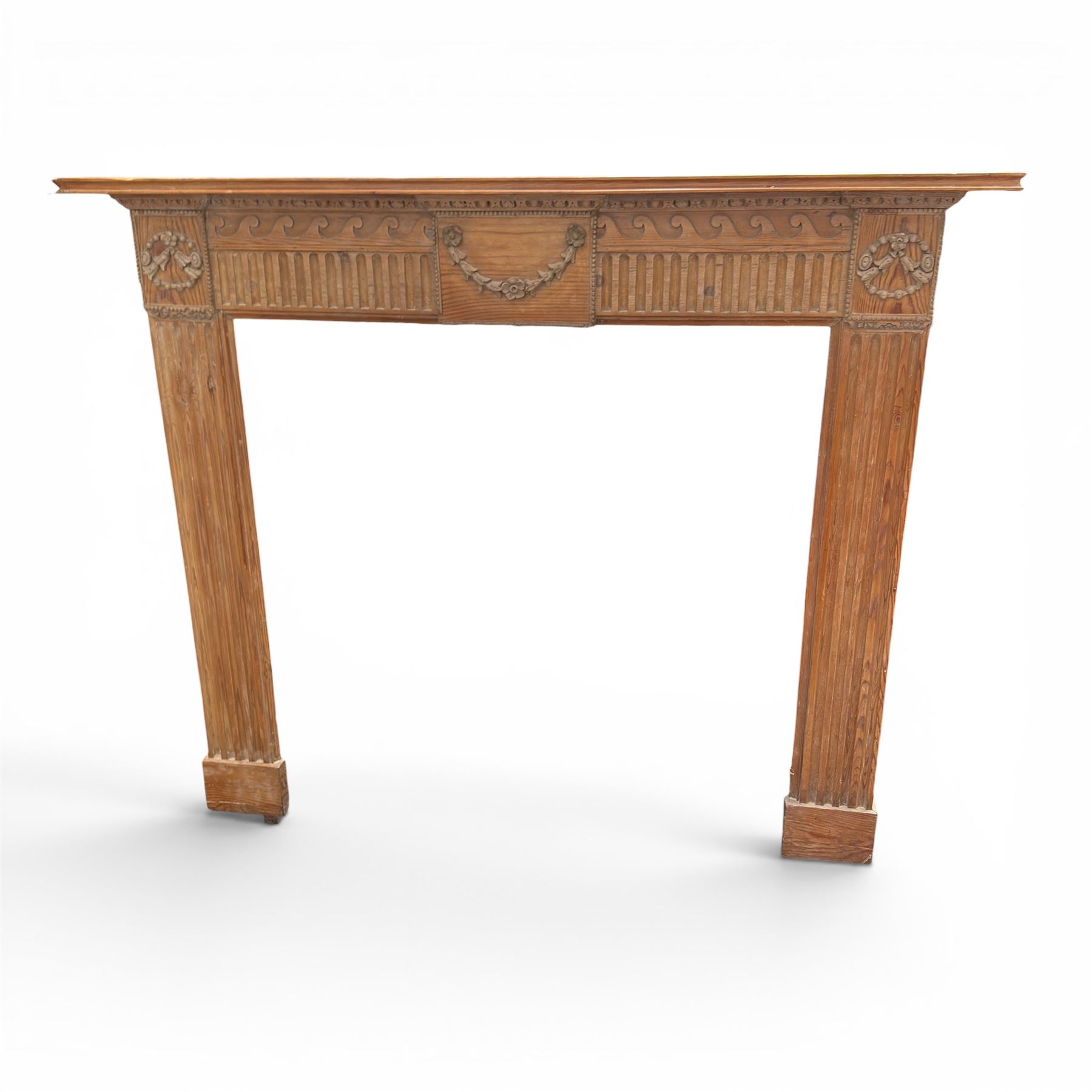 19th century Adams design pine fire surround, egg-and-dart carving over Vitruvian scrolls and fluted frieze, decorated with applied carved festoons and garlands, on fluted uprights