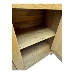 Contemporary light oak sideboard, chamfered rectangular top over two central bevel-edged drawers, flanked by two recessed panelled cupboards enclosing shelving, on square stile supports