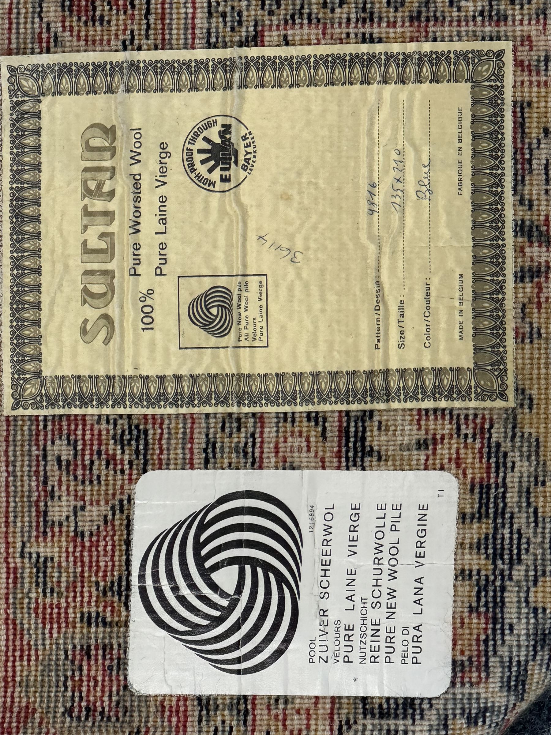 Belgian Sultan woollen ground rug, central navy field densely decorated with floral sprays and geometric patterns (192cm x 135cm); handwoven tribal terracotta ground rug (121cm x 71cm); Persian crimson ground runner, all over stylised floral and foliate motifs (266cm x 94cm)