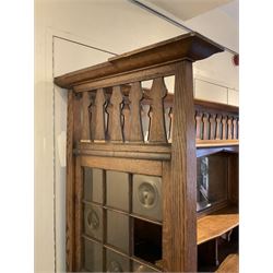 Shapland and Petter - Arts & Crafts period oak dresser, raised gallery top with spade balustrade, central bevelled mirror flanked by two cabinet, astragal glazed doors with yellow tinted glass and bullseye panes, the sides with pierced heart shaped decoration, fitted with two drawers and two double cupboards, enclosed by linenfold panelled doors,  copper work strap hinges and fixtures, on shaped spade feet, the locks stamped 'S&P'