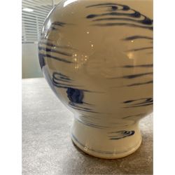 Pair of Chinese Kangxi blue and white porcelain vases, each of baluster form, painted with an outdoor scene containing figures seated upon the ground reading scrolls and holding fans, willow and bamboo tress, rock work and water, H27cm
