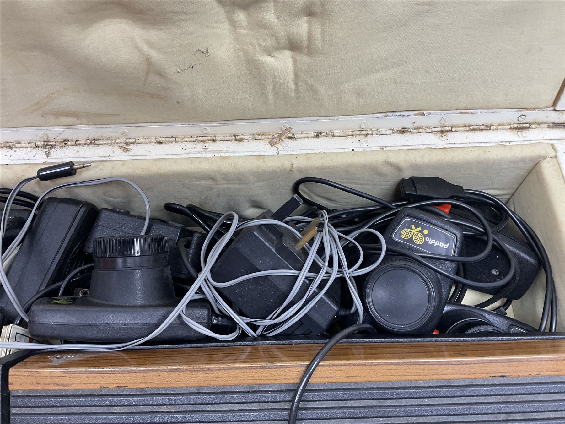 Atari 2600 'Woody' console with various joysticks and controllers etc, and a quantity of game cassettes to include 'Outlaw', 'Air Sea Seattle' and 'Codebreaker' etc housed in white painted wood case