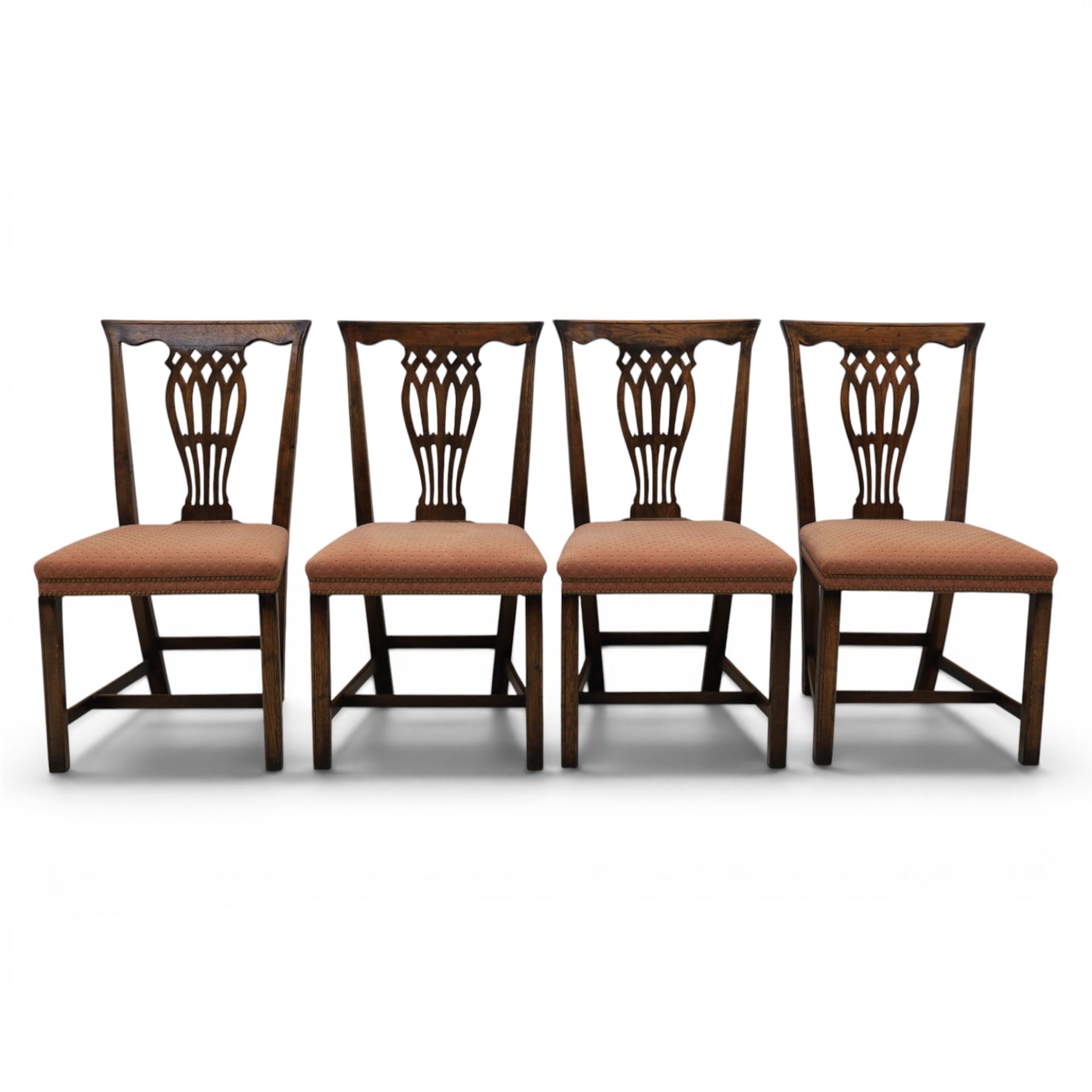 Set of eight George III dining chairs with padded seats, pierced vasiform splat, upholstered seat with brass trim, on square supports with H-stretcher