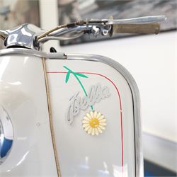 1957 Zündapp Bella R154 Scooter

• Registration: 150 KPU
• Year: 1957
• Model: Bella R154
• Engine: 150cc two-stroke single-cylinder petrol
• Transmission: Four-speed manual
• Odometer reading: 1,727 miles
• Colour: Ivory
• Seating: Dual seat
• V5C: Present
• Original registration book: Present
• Keys: 1

A characterful 1957 Zündapp Bella R154 scooter, finished in ivory with a contrasting brown dual seat and displaying an odometer reading of 1,727 miles.

The Bella R154 formed part of Zündapp’s distinctive range of German touring scooters, combining a 150cc air-cooled two-stroke engine with four-speed transmission, large wheels and substantial pressed-steel bodywork. This example retains its enclosed front apron, central headlamp, chrome handlebars, brightwork, period VDO speedometer and decorative Bella badging.

An operation and maintenance manual is include and accompanied by its V5C and original registration book from 1957.

This vehicle forms part of the Estate of the Late John Sills and is offered for sale by the Executors, confirming a genuine reason for sale.