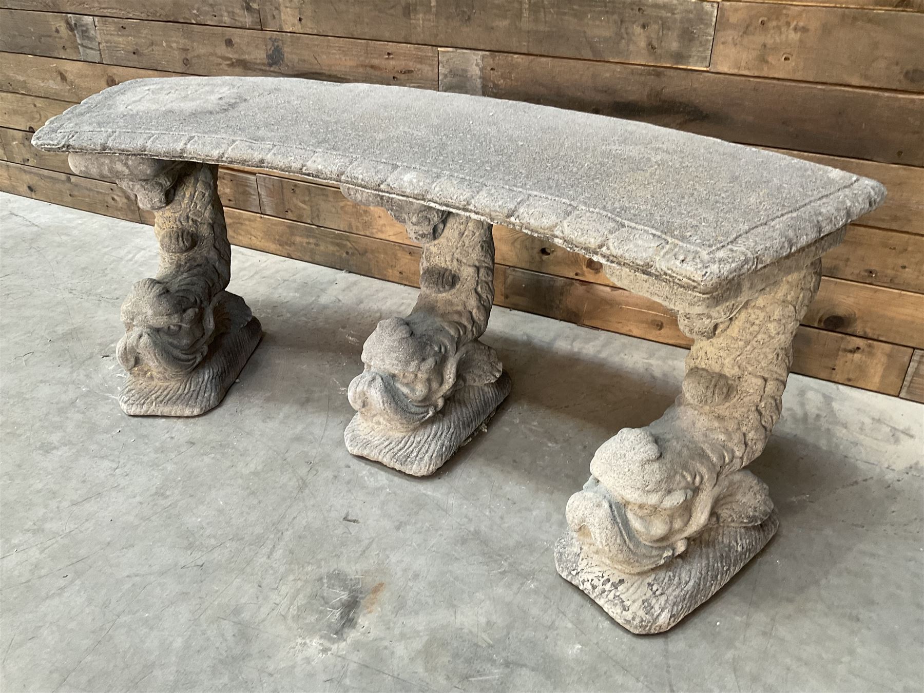 Cast stone four piece curved Dolphin bench, set with three dolphin pillars, curved rectangular slab top with detailed border