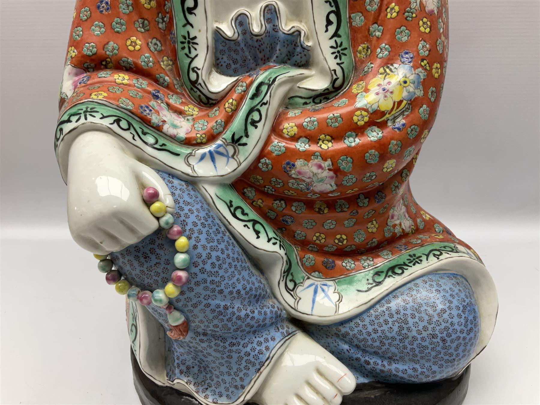 Tall Chinese polychrome figure of Guanyin (Guan Yin), the Goddess of Mercy and compassion, the Bodhisattva modelled seated and holding a rosary donning elaborate floral robes and beads, with four character seal marks beneath, H53cm
