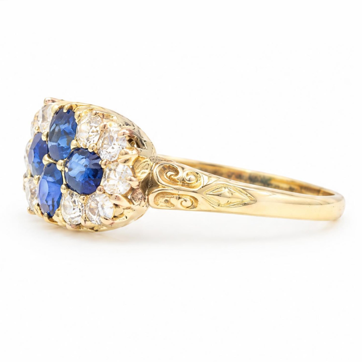 Victorian sapphire and diamond cluster ring, four oval cut sapphires, surrounded by eight old cut diamonds, with scroll design shoulders