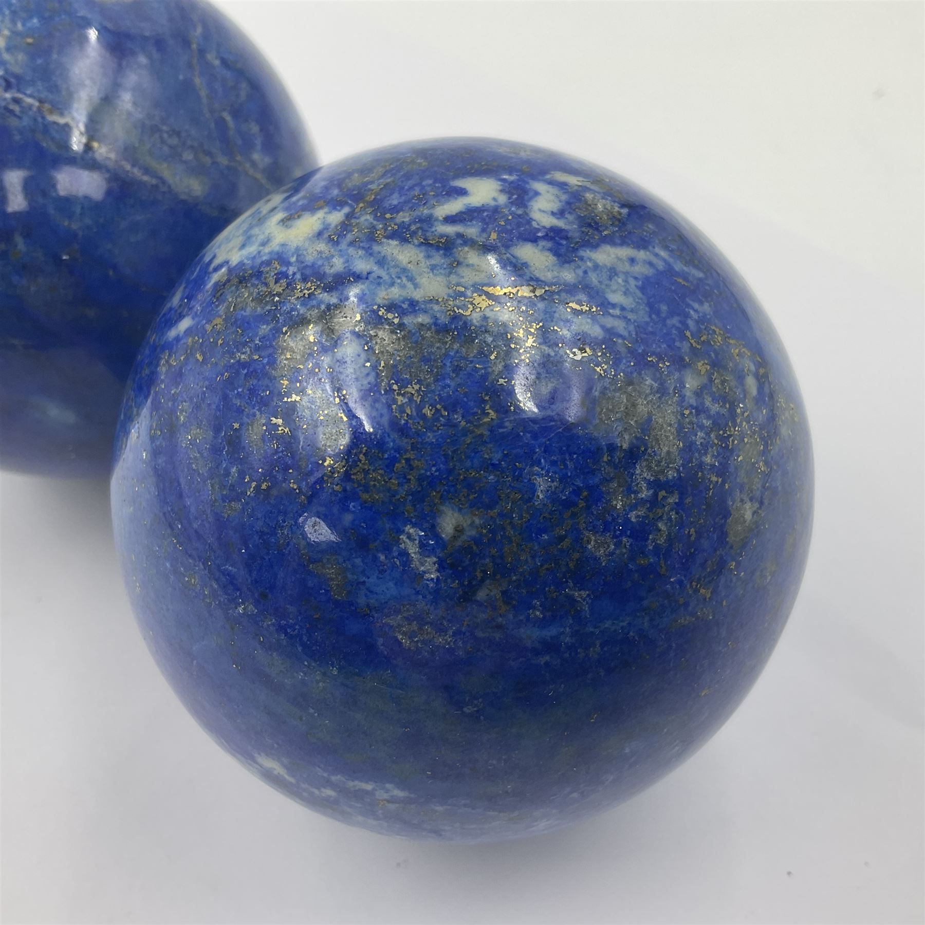 Pair of Lapis lazuli spheres, upon a carved stone stands, D8cm