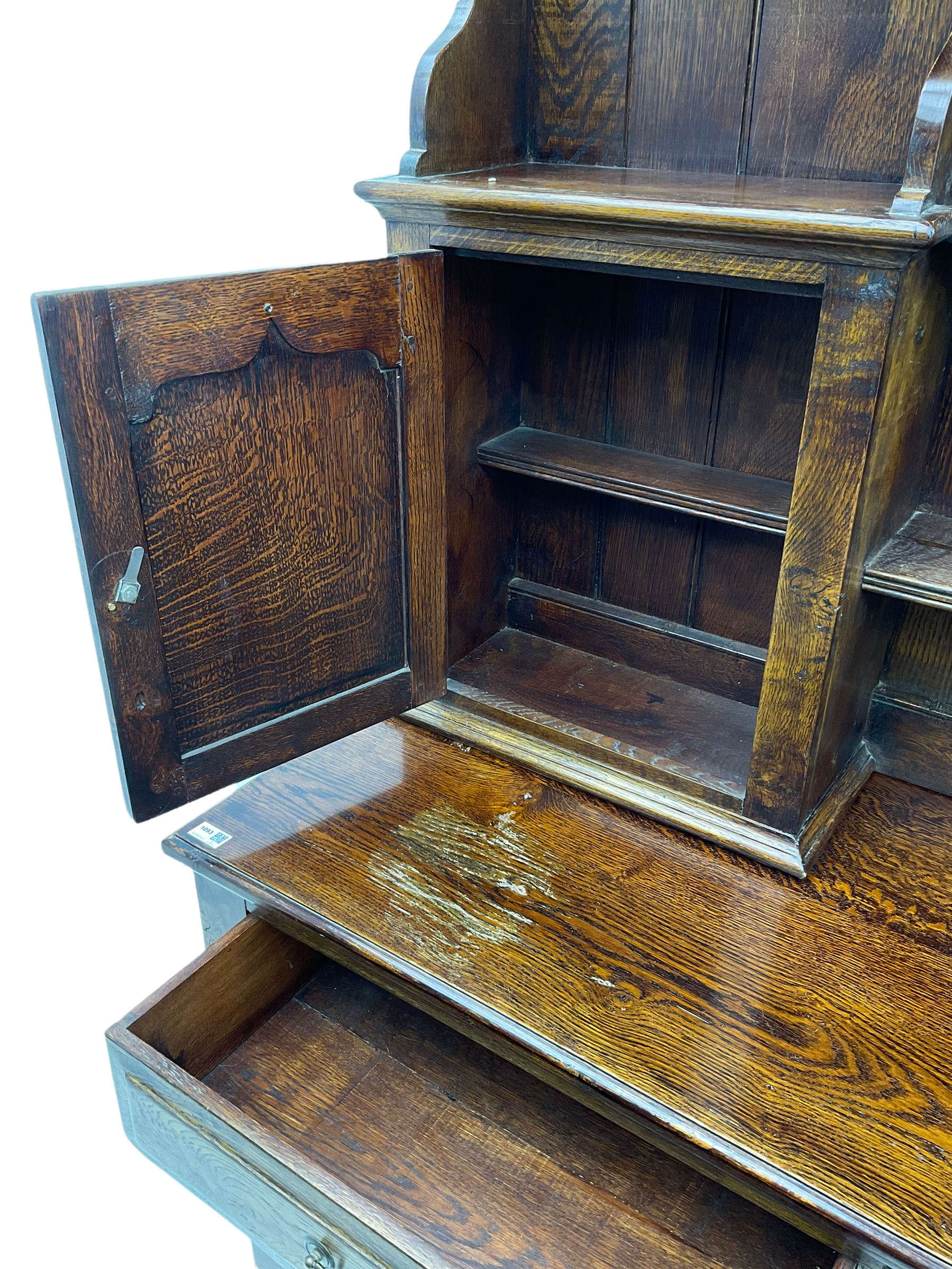 Traditional oak dresser, the moulded cornice over shaped apron, three heights plate rack fitted with two cupboards, the base fitted with six drawers and two double cupboards, panelled pointed ogee arched doors, on bracket feet